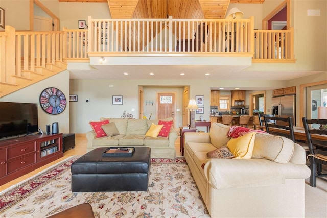 living area featuring recessed lighting, stairs, and a towering ceiling
