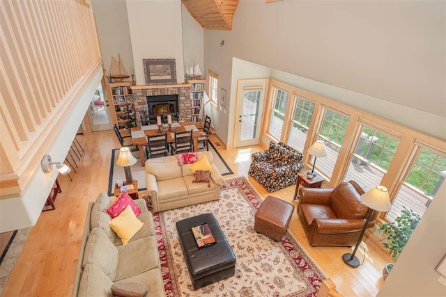 living area featuring high vaulted ceiling, wood finished floors, and a fireplace