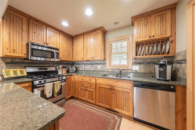 kitchen with a sink, appliances with stainless steel finishes, and backsplash