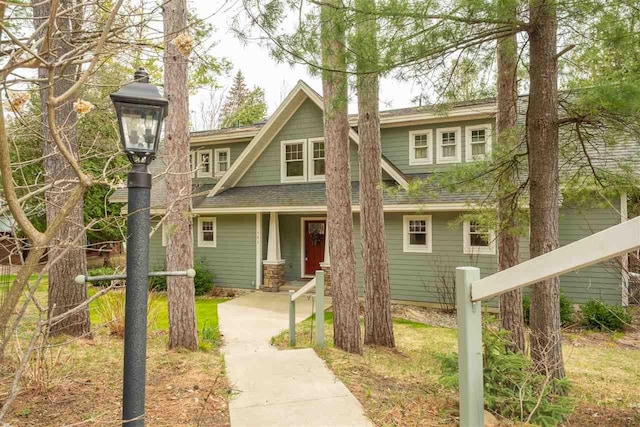 craftsman inspired home featuring roof with shingles and a porch