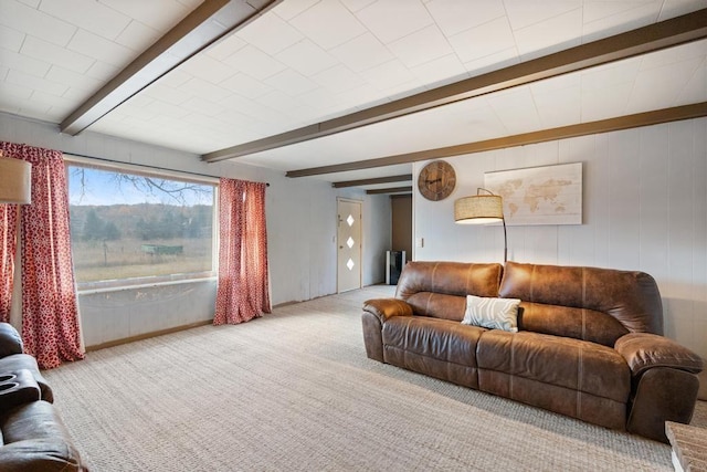 carpeted living room featuring beamed ceiling