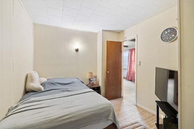 bedroom featuring baseboards and light carpet