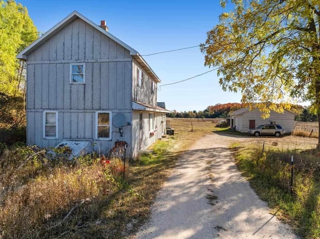 view of side of home with board and batten siding and driveway