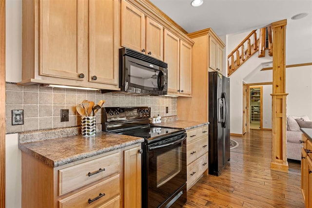 kitchen featuring decorative backsplash, light wood finished floors, light brown cabinetry, and black appliances