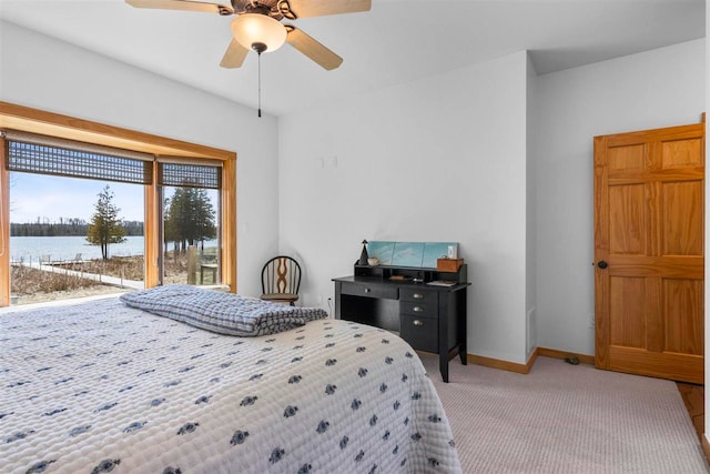 6650 S Beach Dr, Alanson, MI 49706 - bedroom with a ceiling fan, access to exterior, baseboards, a water view, and carpet flooring