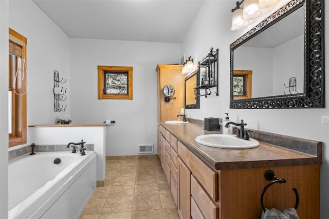 bathroom with visible vents, a sink, a bath, and double vanity