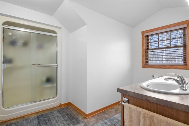 full bathroom featuring baseboards, a shower stall, lofted ceiling, and vanity
