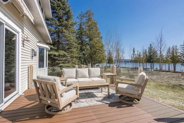 wooden terrace featuring an outdoor hangout area, fence, and a water view