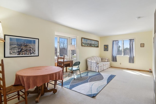 living room featuring a healthy amount of sunlight, baseboards, and carpet