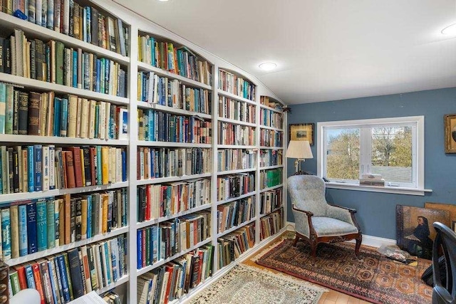 sitting room with baseboards and bookshelves