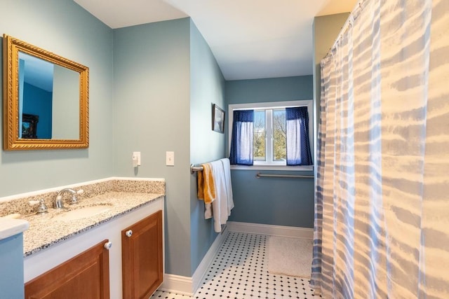 full bathroom with vanity and baseboards