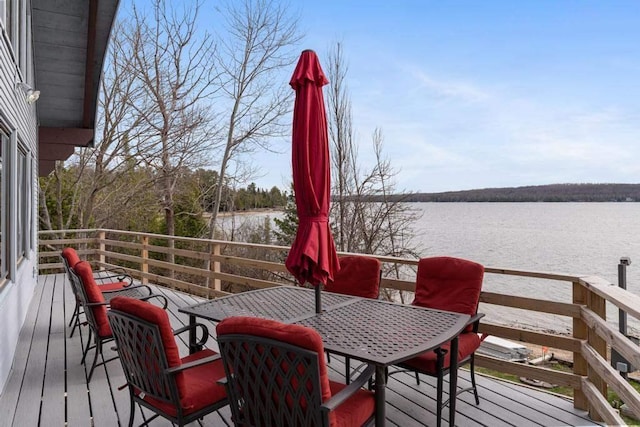 deck featuring outdoor dining area and a water view