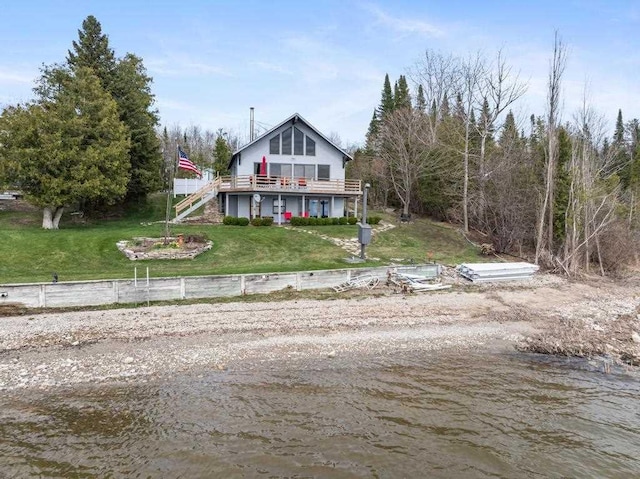 view of front of property with stairs, a front lawn, and a deck