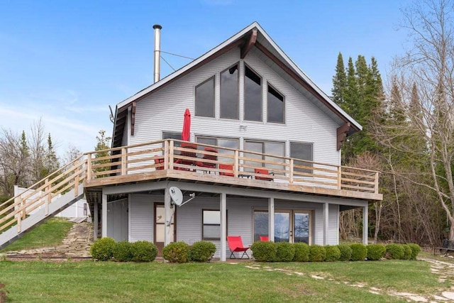 rear view of property with a yard and a deck