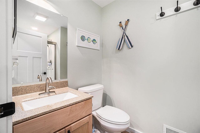 4852 Six Mile Lake Rd, Ellsworth, MI 49729 - bathroom featuring vanity, walk in shower, visible vents, and toilet