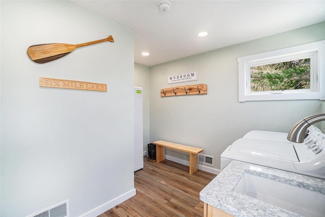 4852 Six Mile Lake Rd, Ellsworth, MI 49729 - laundry room with laundry area, baseboards, wood finished floors, visible vents, and washing machine and dryer