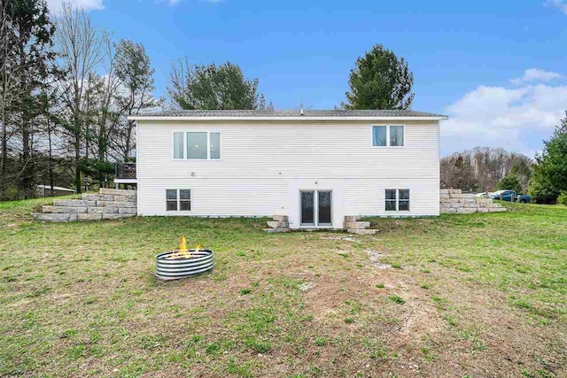 4852 Six Mile Lake Rd, Ellsworth, MI 49729 - back of property featuring a lawn and an outdoor fire pit