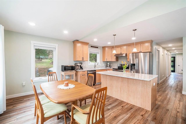 4852 Six Mile Lake Rd, Ellsworth, MI 49729 - kitchen with light brown cabinets, light wood-type flooring, a center island, under cabinet range hood, and stainless steel appliances