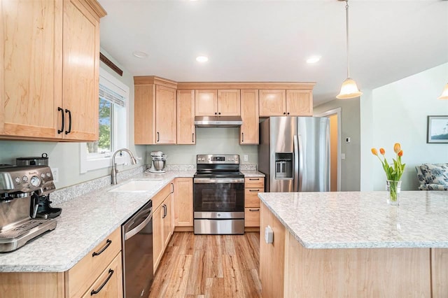 4852 Six Mile Lake Rd, Ellsworth, MI 49729 - kitchen with appliances with stainless steel finishes, a sink, light brown cabinets, under cabinet range hood, and light wood-style flooring