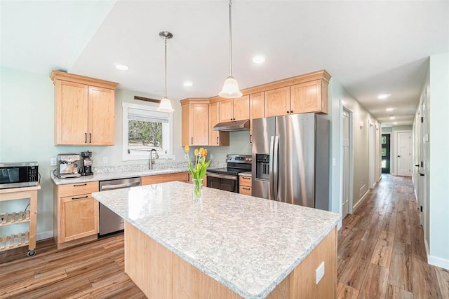 4852 Six Mile Lake Rd, Ellsworth, MI 49729 - kitchen with appliances with stainless steel finishes, a sink, light wood-style floors, light brown cabinets, and under cabinet range hood