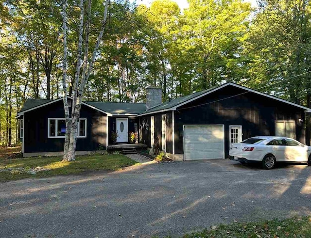 8118 E Mitchell St, Petoskey, MI 49770 - view of front of home with a garage, driveway, and a chimney