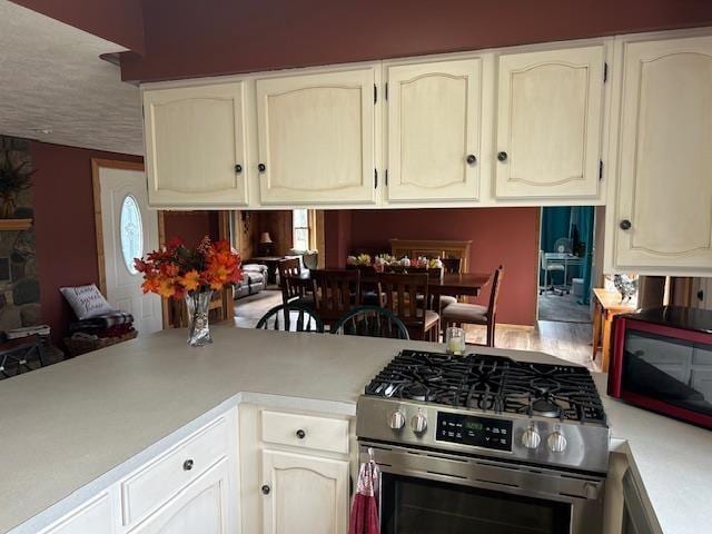 8118 E Mitchell St, Petoskey, MI 49770 - kitchen featuring light countertops, stainless steel range with gas cooktop, and white cabinetry