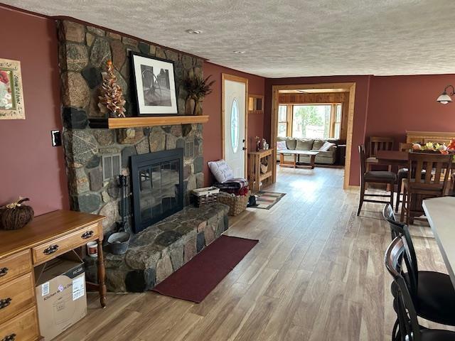 8118 E Mitchell St, Petoskey, MI 49770 - living room with a fireplace, a textured ceiling, and wood finished floors