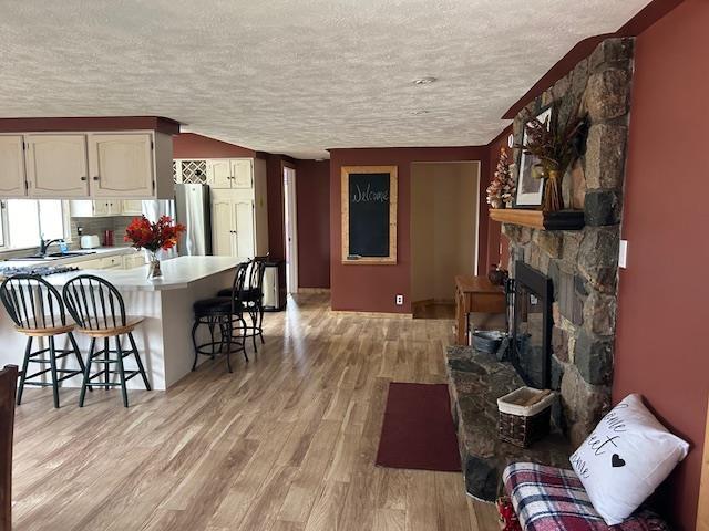 8118 E Mitchell St, Petoskey, MI 49770 - kitchen featuring light countertops, a kitchen breakfast bar, light wood finished floors, and a textured ceiling