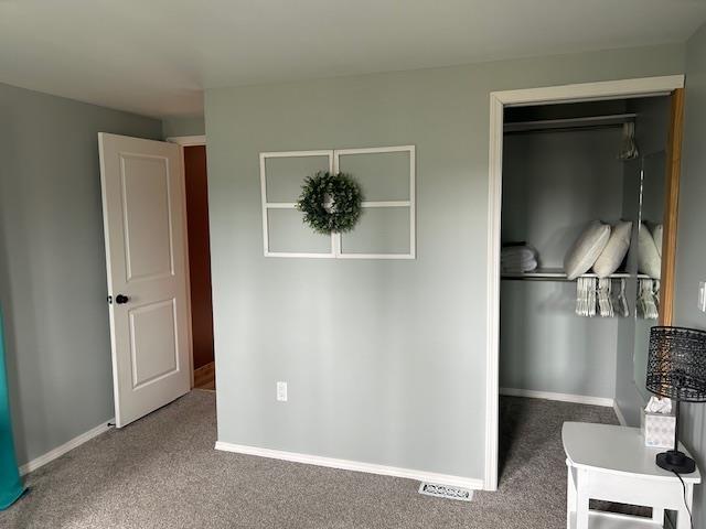 8118 E Mitchell St, Petoskey, MI 49770 - unfurnished bedroom featuring baseboards, carpet, and a closet