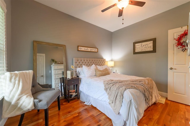 bedroom with baseboards, wood finished floors, and a ceiling fan