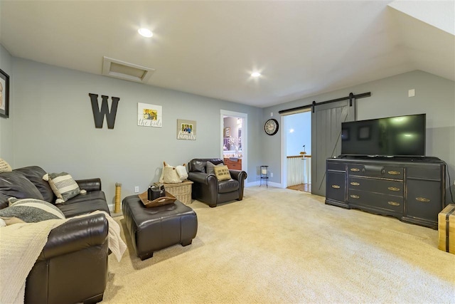 living room featuring recessed lighting, a barn door, attic access, and light colored carpet