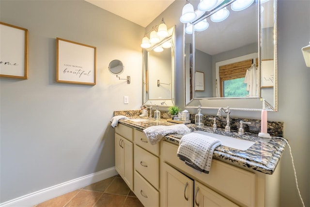 full bathroom with a sink, tile patterned flooring, double vanity, and baseboards