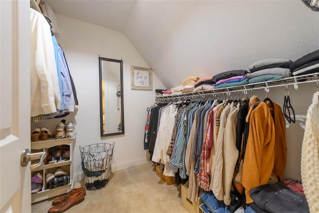 walk in closet featuring lofted ceiling and carpet floors