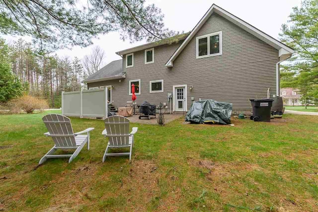 rear view of house with a lawn and a patio