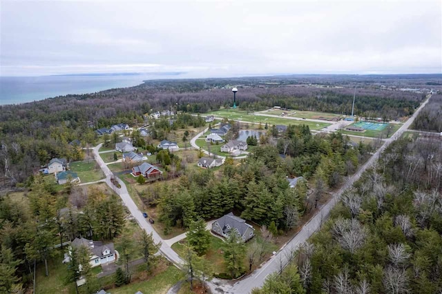 drone / aerial view featuring a water view and a forest view