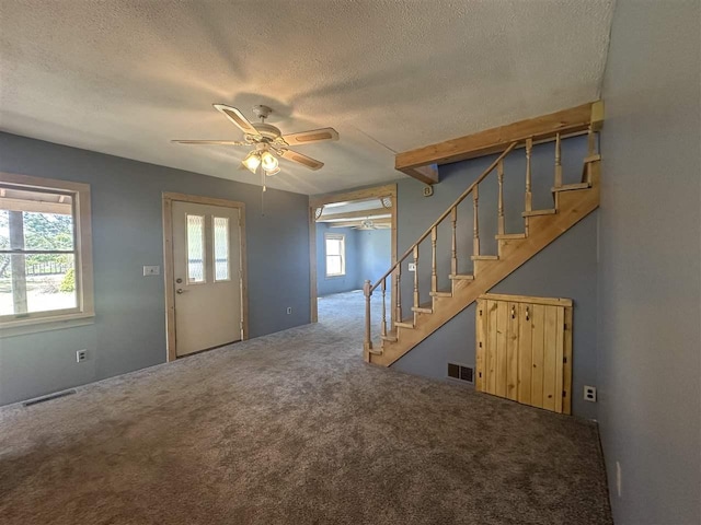 4445 Howard Rd, Petoskey, MI 49770 - entrance foyer with a wealth of natural light, a textured ceiling, stairway, and ceiling fan