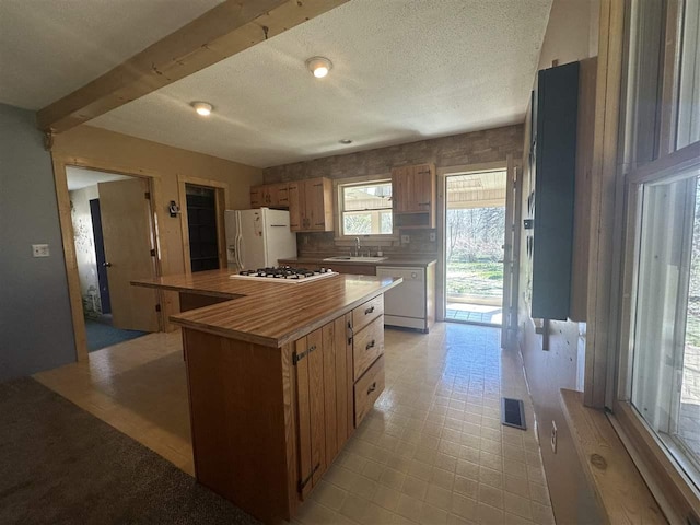 4445 Howard Rd, Petoskey, MI 49770 - kitchen with a sink, visible vents, white appliances, light countertops, and a kitchen island