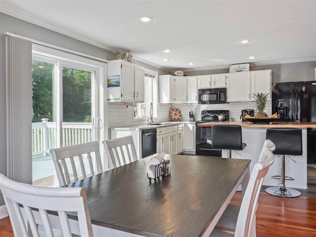 7906 Ferry Rd, East Jordan, MI 49727 - dining area with ornamental molding, recessed lighting, and dark wood-style floors