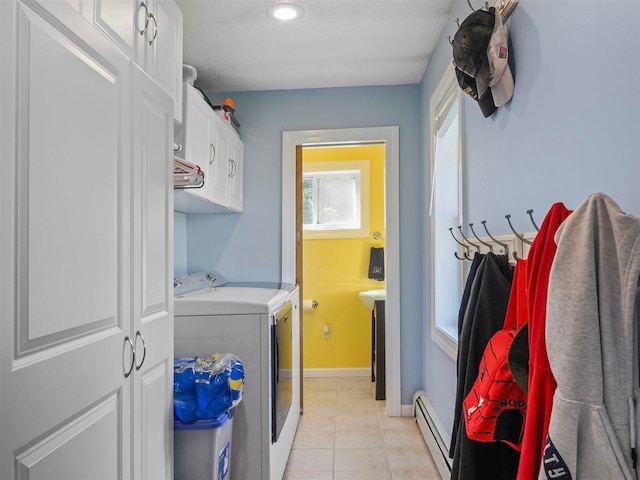 7906 Ferry Rd, East Jordan, MI 49727 - laundry area with light tile patterned floors, cabinet space, baseboards, a baseboard heating unit, and independent washer and dryer