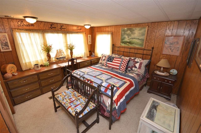 bedroom featuring light colored carpet and wood walls