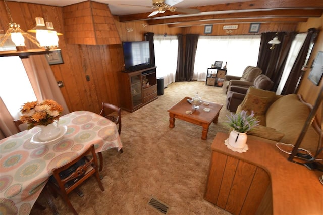 living room featuring a ceiling fan, beamed ceiling, light carpet, and a healthy amount of sunlight