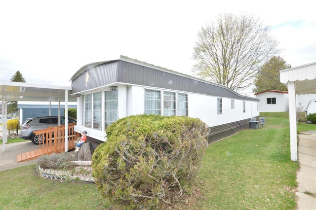 view of home's exterior featuring a yard, a carport, and central AC