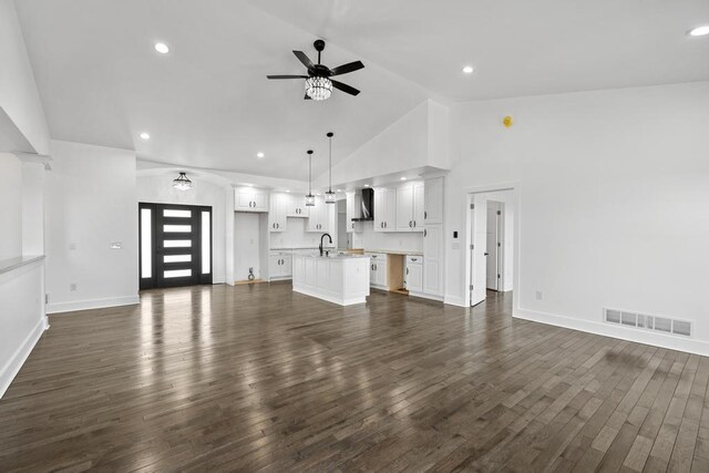 358 Harbor View Ln, Petoskey, MI 49770 - unfurnished living room with a ceiling fan, high vaulted ceiling, a sink, visible vents, and dark wood-style floors