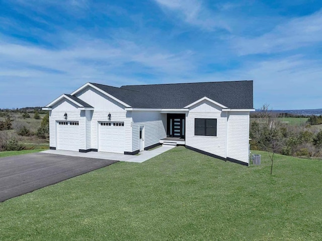 358 Harbor View Ln, Petoskey, MI 49770 - view of front of house with aphalt driveway, an attached garage, a shingled roof, and a front yard