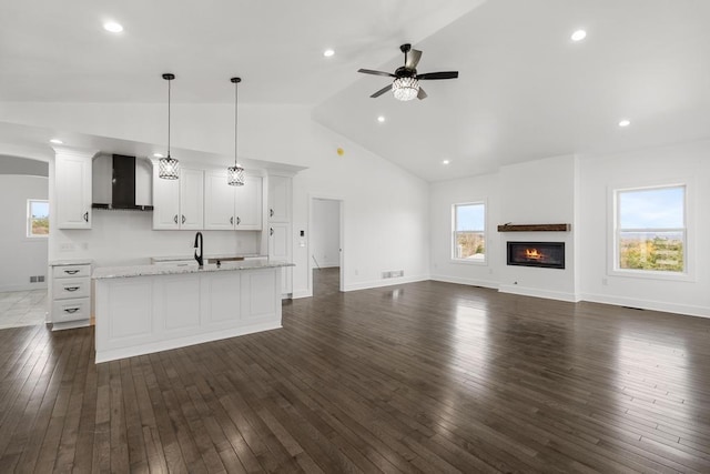 358 Harbor View Ln, Petoskey, MI 49770 - unfurnished living room featuring a ceiling fan, baseboards, a glass covered fireplace, high vaulted ceiling, and dark wood-style floors
