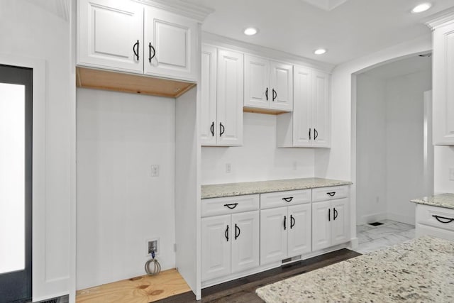 358 Harbor View Ln, Petoskey, MI 49770 - kitchen with recessed lighting, white cabinetry, arched walkways, light stone countertops, and baseboards