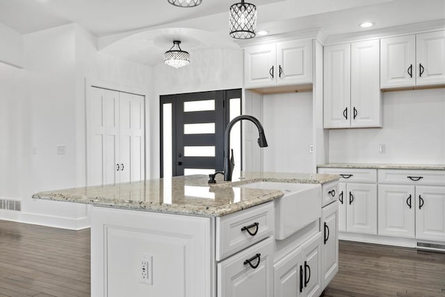 358 Harbor View Ln, Petoskey, MI 49770 - kitchen with a sink, visible vents, dark wood finished floors, an island with sink, and white cabinetry