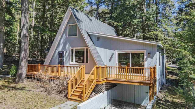 4488 Fourth St, Walloon Lake, MI 49796 - view of front of property with roof with shingles, a wooden deck, and stairs