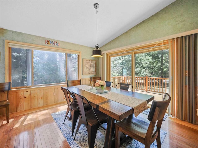 4488 Fourth St, Walloon Lake, MI 49796 - dining room with lofted ceiling, light wood finished floors, and wood walls