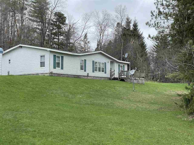 manufactured / mobile home with a front lawn and a wooden deck